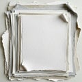 A stack of torn-edged paper sheets in varying shades of white, gray, and beige Royalty Free Stock Photo