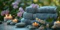 A stack of towels with flowers and candles on a table Royalty Free Stock Photo