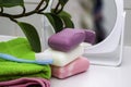 a stack of towels soap toothbrush mirror and houseplant on the bathroom table Royalty Free Stock Photo