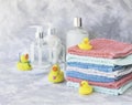 Stack of towels with yellow rubber bath ducks on white marble background, space for text, selective focus Royalty Free Stock Photo