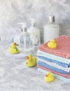 Stack of towels with yellow rubber bath ducks on white marble background, space for text, selective focus Royalty Free Stock Photo