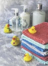 Stack of towels with yellow rubber bath ducks on white marble background, space for text, selective focus Royalty Free Stock Photo