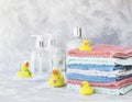 Stack of towels with yellow rubber bath ducks on white marble background, space for text, selective focus Royalty Free Stock Photo