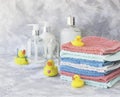 Stack of towels with yellow rubber bath ducks on white marble background, space for text, selective focus Royalty Free Stock Photo