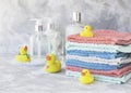 Stack of towels with yellow rubber bath ducks on white marble background, space for text, selective focus Royalty Free Stock Photo