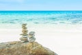 Stack tower of stone balances on a beach with water sea and blue sky nature Royalty Free Stock Photo