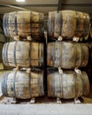 A stack of 6 traditional full whisky barrels, set down to mature, in a large warehouse Royalty Free Stock Photo