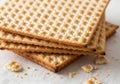 Stack of traditional matzah crackers on a light surface with crumbs around Royalty Free Stock Photo