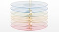 Stack of translucent colored circular discs with liquid oil drops falling through each layer, creating ripples on the Royalty Free Stock Photo