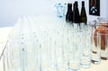 Stack of transparent glasses for wine, juice, bottles of wine and water Royalty Free Stock Photo