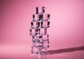 Stack of transparent ice cubes on pink background with shadow Royalty Free Stock Photo