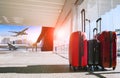 stack of traveling luggage in airport terminal with passenger plane approch for take off on runway Royalty Free Stock Photo