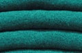 Stack of trend Quetzal Green woolen sweaters close-up, texture, background