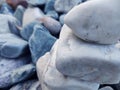 Stack of triangular stones.Group of white and colorful Stones.Pebble tower on the stones seaside.Stones pyramid on pebble beach