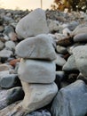 Stack of triangular stones.Group of white and colorful Stones.Pebble tower on the stones seaside.Stones pyramid on pebble beach