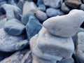 Stack of triangular stones.Group of white and colorful Stones.Pebble tower on the stones seaside.Stones pyramid on pebble beach