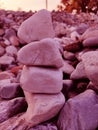 Stack of triangular stones.Group of white and colorful Stones.Pebble tower on the stones seaside.Stones pyramid on pebble beach