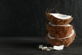 Stack tropical coconut on wooden table against black background