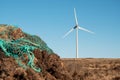 Stack of turf in a bog next to wind farm turbine. Clean new and dirty old source of energy. Natural and artificial product in Royalty Free Stock Photo