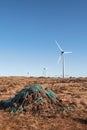 Stack of turf in a bog next to wind farm turbine. Clean new and dirty old source of energy. Natural and artificial product in Royalty Free Stock Photo