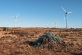 Stack of turf in a bog next to wind farm turbine. Clean new and dirty old source of energy. Natural and artificial product in Royalty Free Stock Photo