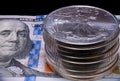 Stack of U.S. Silver Eagle bullion coins on a hundred dollar bill