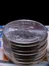 Stack of U.S. Silver Eagle coins on a hundred dollar bill