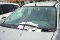 A stack of unpaid parking fine receipts on the windshield