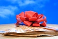 Stack of usa dollars and bow on blue sky background, money gift concept Royalty Free Stock Photo