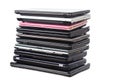 Stack of used laptops in different colors and models. T