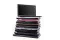 Stack of used laptops in different colors and models. T