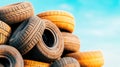A stack of used tires against a bright blue sky, showcasing the texture and patterns of rubber materials Royalty Free Stock Photo