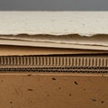 A stack of various cardboard and paper materials. The top layer is rough white paper Royalty Free Stock Photo
