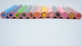 Stack of various colored wood pencil crayons scattered across a white background Royalty Free Stock Photo