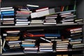 Stack of various leather-bound diaries or books in a gray bookcase