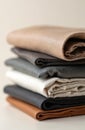 Stack of various leather samples in neutral shades like beige, brown, grey, black, white. Different textures visible, from soft Royalty Free Stock Photo