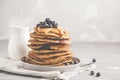 Stack vegan blueberry pancakes with peanut butter and syrup.