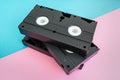 Stack of 3 VHS tapes on pink and blue background.