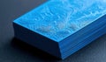 A stack of vibrant blue cards features an exquisite embossed floral pattern and striking texture. Royalty Free Stock Photo