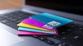 Stack of vibrant digital payment cards placed on sleek laptop keyboard. Clean modern workspace highlights technology and Royalty Free Stock Photo