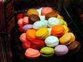 Stack of vibrant Multicolored macaroons, colorful french cookies macarons dark background displayed in Spanish pastry shop