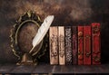 Stack vintage books on a shelf, bronze empty frame and Ancient inkwell Royalty Free Stock Photo