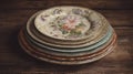 Stack of vintage floral decorative plates on rustic wooden table surface Royalty Free Stock Photo