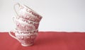 Stack of vintage tea cups on red table Royalty Free Stock Photo