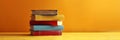 Stack of vivid books. A neat pile of vintage reading books on yellow background. Concept of academic collection