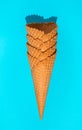 A stack of waffle ice cream cones on a blue background in hard light. Royalty Free Stock Photo