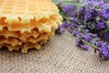 Stack of waffles and bunch of lavender on a burlap fabric texture background. Royalty Free Stock Photo