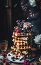 A stack of waffles sitting on top of a table a colorized photo,