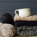 Stack of warm clothes from knitted knitwear with a cup of coffee Royalty Free Stock Photo