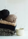 Stack of warm clothes from knitted knitwear with a cup over whit Royalty Free Stock Photo